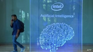 A visitor at Intel's Artificial Intelligence (AI) Day walks past a signboard during the event in the Indian city of Bangalore on April 4, 2017. (Photo by MANJUNATH KIRAN / AFP)