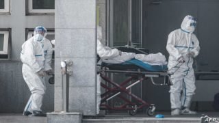 Medical staff members carry a patient into the Jinyintan hospital, where patients infected by a mysterious SARS-like virus are being treated, in Wuhan in China's central Hubei province on January 18, 2020. - The true scale of the outbreak of a mysterious SARS-like virus in China is likely far bigger than officially reported, scientists have warned, as countries ramp up measures to prevent the disease from spreading. (Photo by STR / AFP) / China OUT