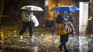 People take cover from the rain as they walk on Jaffa Road in the city center of Jerusalem on December 20, 2021. Photo by Olivier Fitoussi/Flash90 *** Local Caption *** éøåùìéí
àðùéí
÷åøåðä
îñéëåú
äåìëéí
îæâ àååéø
îèøéä